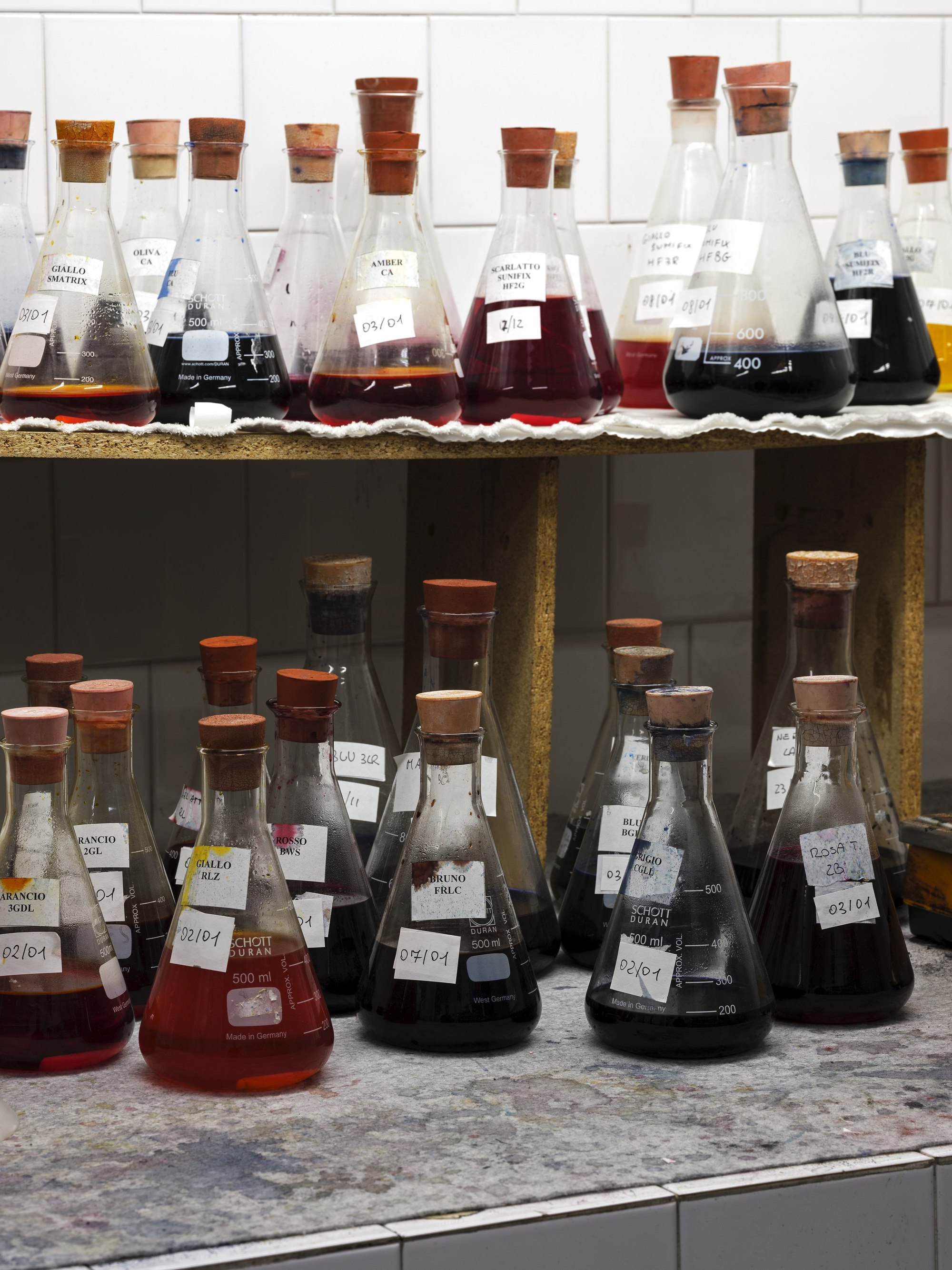Dye flasks with handwritten colour codes in the Stone Island colour laboratory