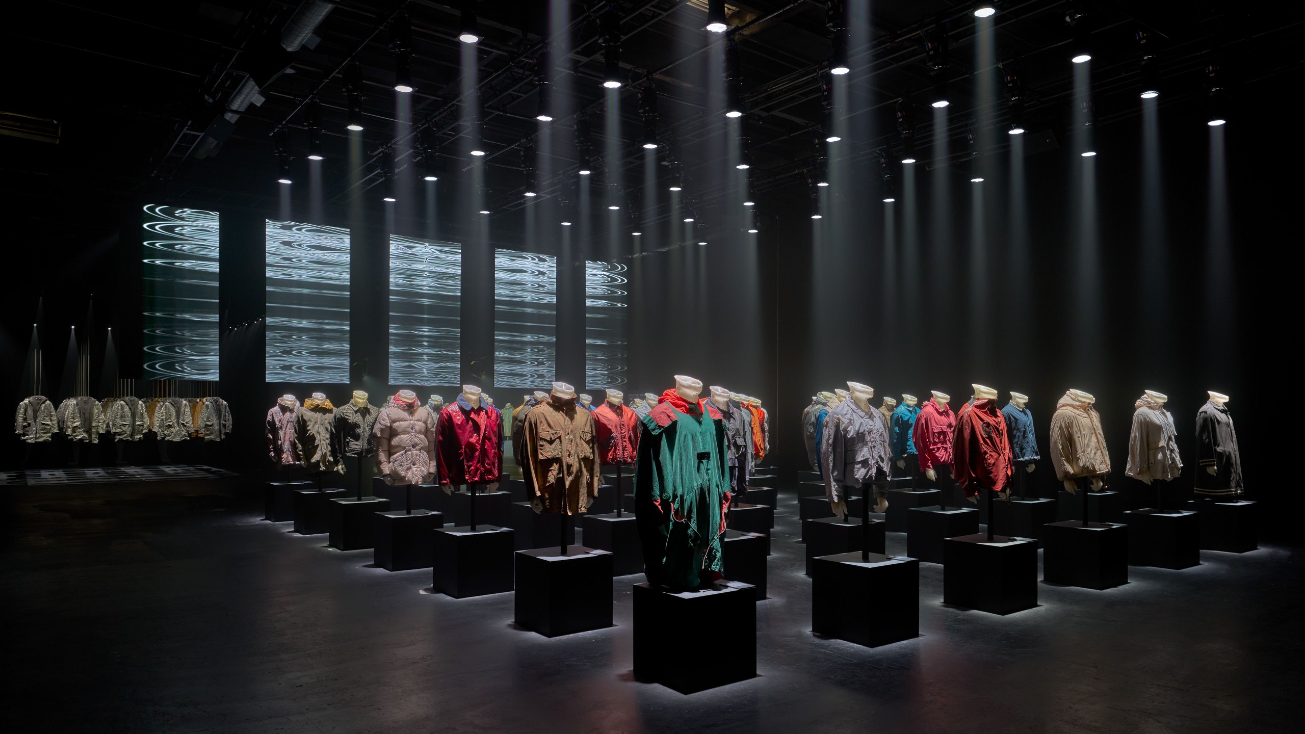 The Stone Island archive room: garments displayed on plinths under beams of light